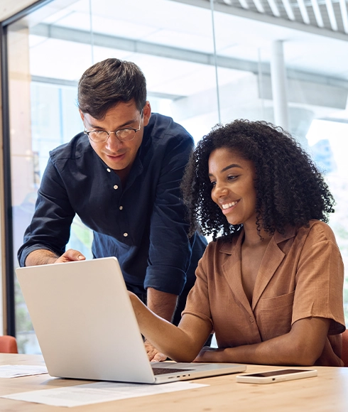 Deux collaborateurs consultant un ordinateur pour analyser les indicateurs de la performance et suivre les résultats de l’entreprise.