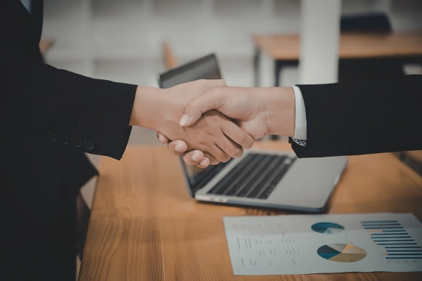 Deux professionnels se serrent la main pour illustrer le partenariat entre Prophix et AGP, premier partenaire Prophix en France.